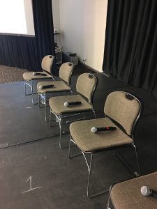 Microphones laid out on chairs, ready for a panel at WordCamp US 2019
