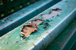 Paint peeling off a frosty metal bar