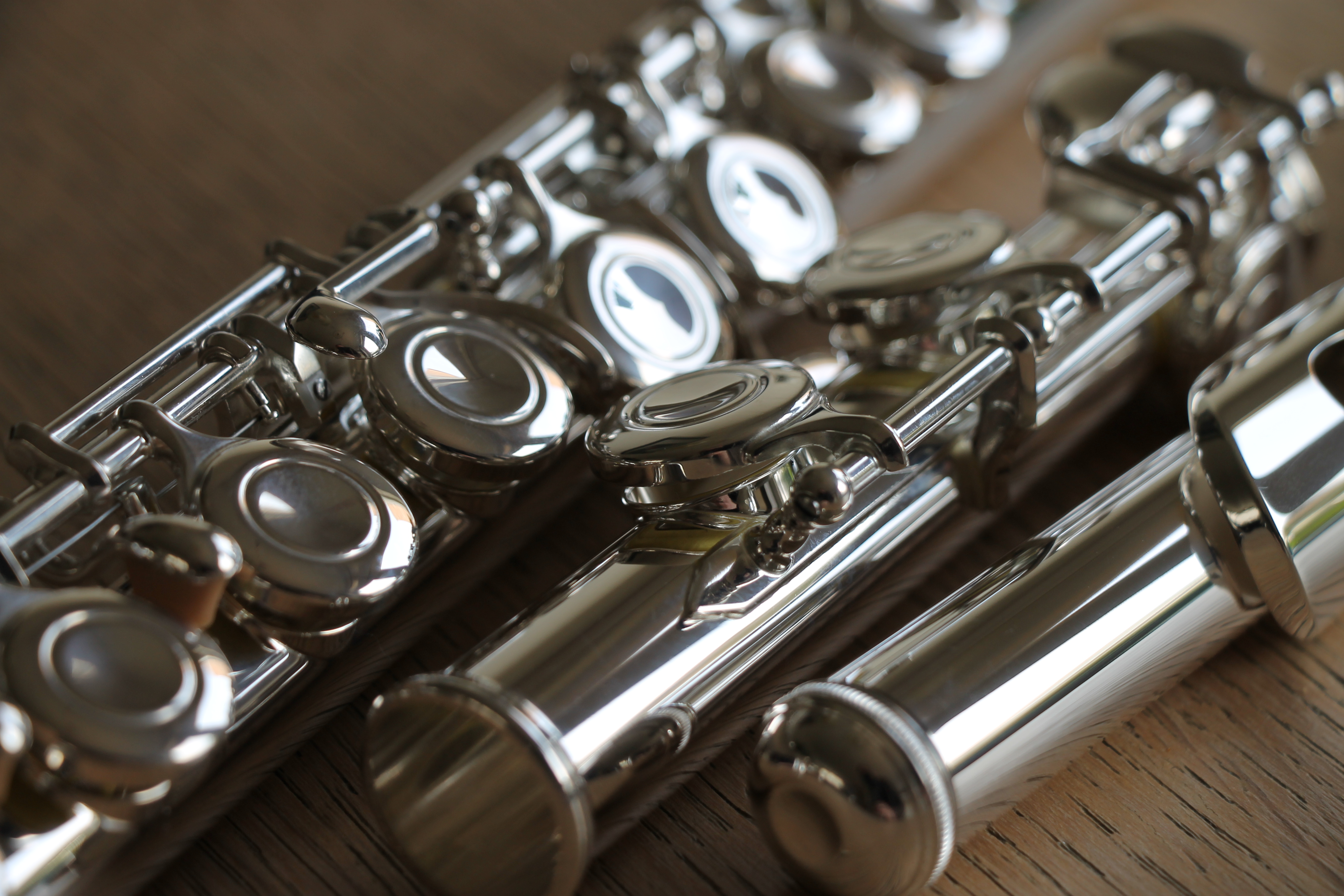 Close-up of a silver-plated flute on a wooden surface