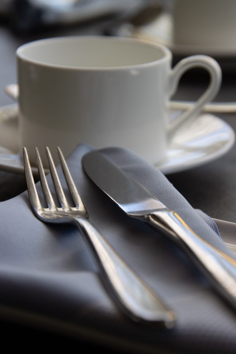 Closeup view of an empty coffee cup and utensils