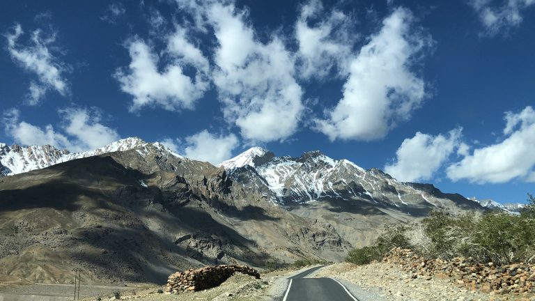 Beautiful montains with road, clouds and snow.