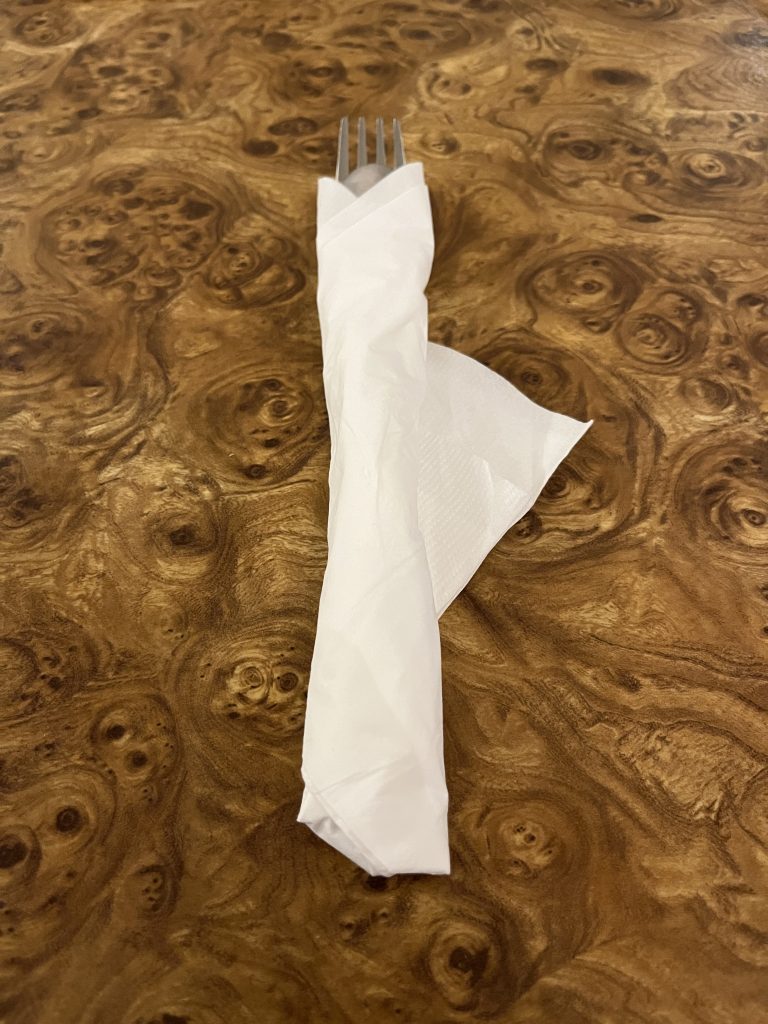 Restaurant silverware, wrapped in a napkin