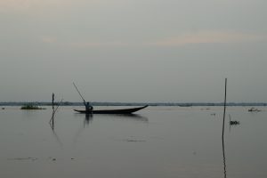 A boatman is riding his boat