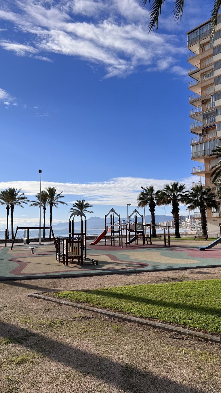 Awakening in the playground, with sea and mountains in the background