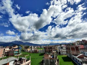 A clean sky with Clouds, hills in the back and houses in Kathmandu, Nepal. 