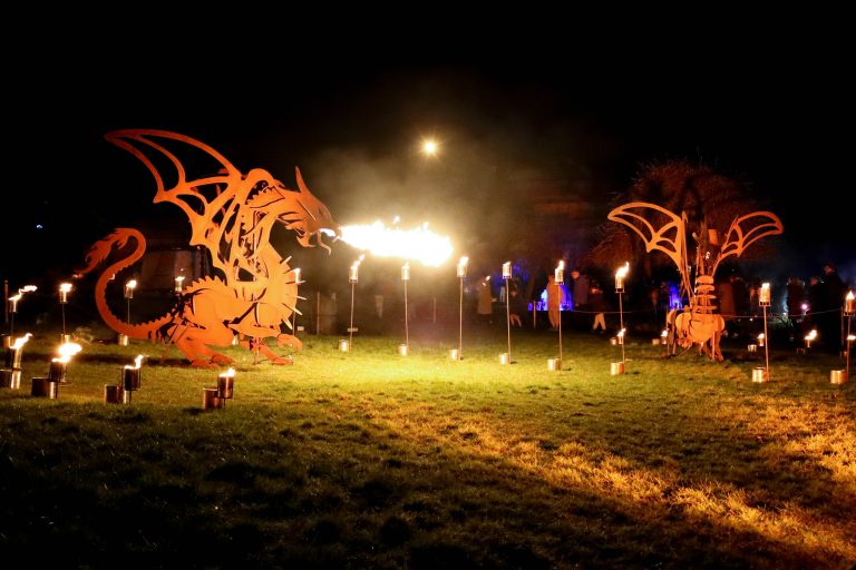 Dragon statues at night breathing fire.