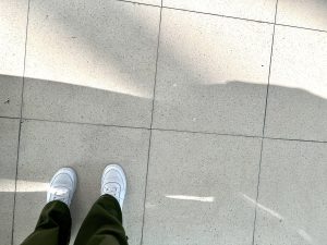 white sneakers on a tile floor
