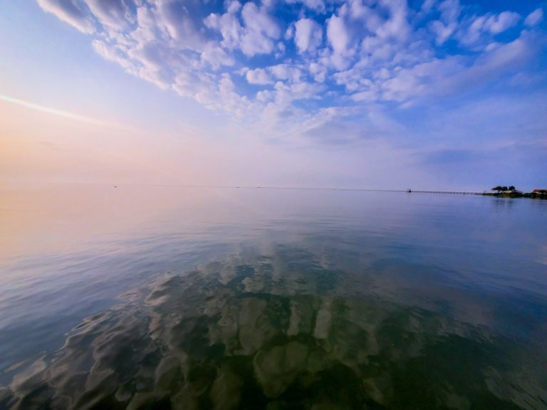 Clouds touching down Lake Victoria in the morning showing a skyline and beach in the far end, photo taken at Uganda Wildlife Education Centre on the floating restaurant