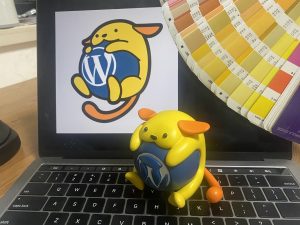 Entity wapuu pictured with Pantone color card, taken in (2022), during sample development.