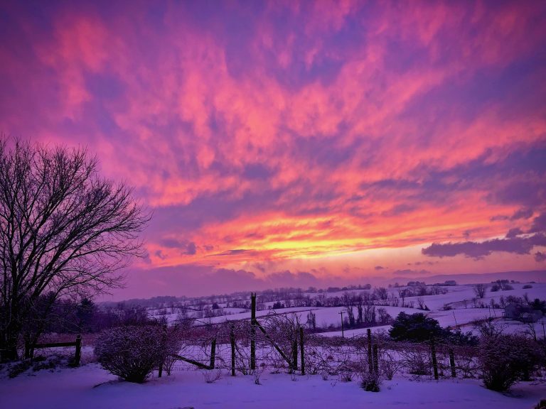 Sunset at winter over snowy farm fields