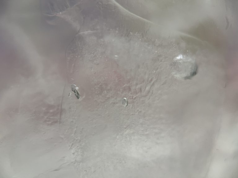 A very close shot of ice, with a tiny bubble inside.