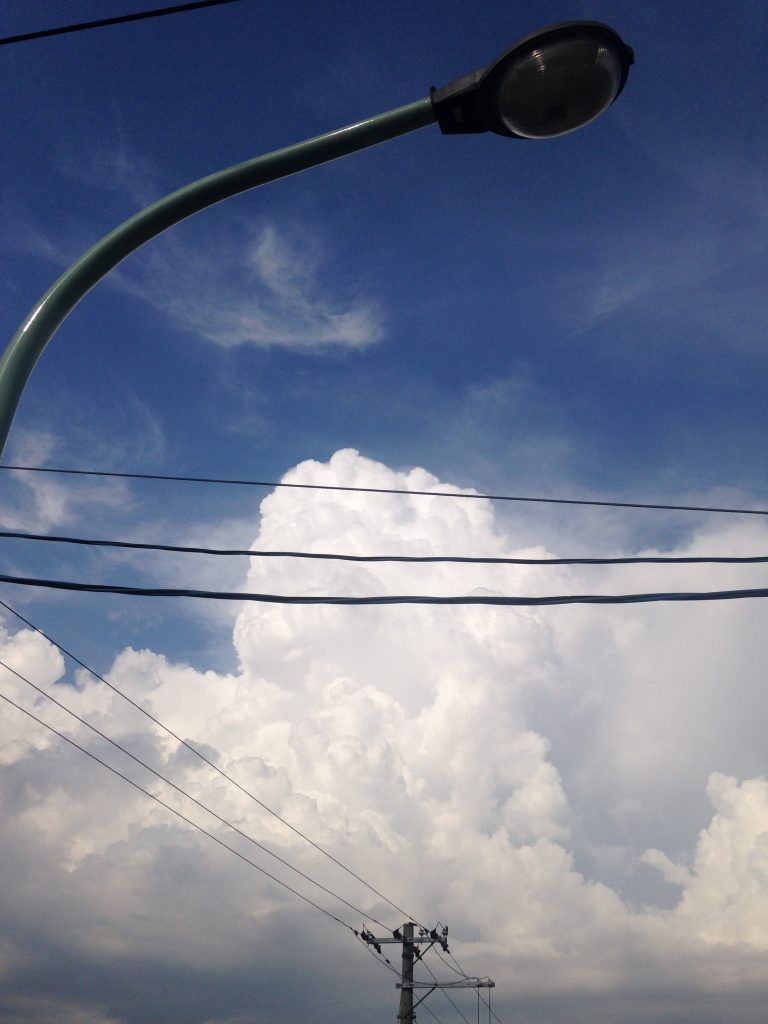 Clouds with a street lamp and wires in the foreground