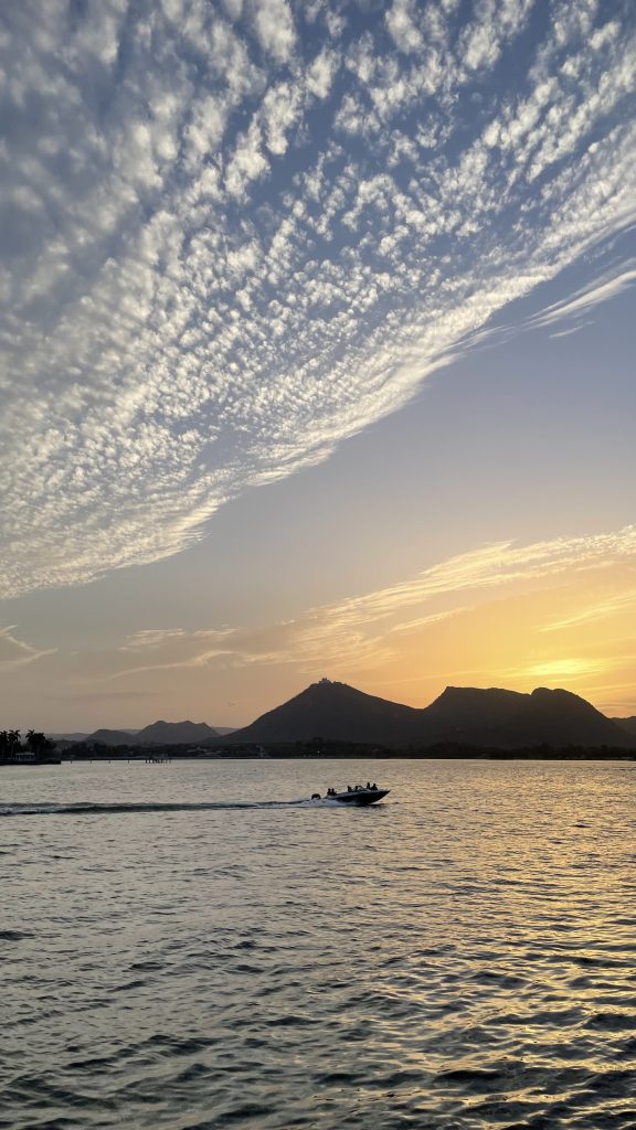 Beautiful sunset view of Fateh Sagar Lake Udaipur.  Boat speeding across a lake.