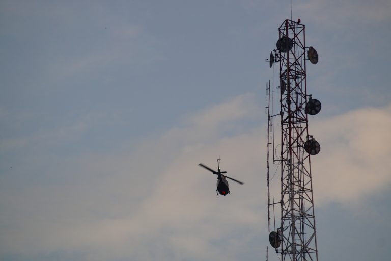 Helicopter passing a tower