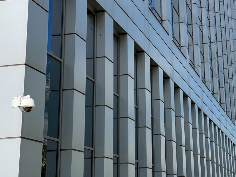 minimalistic photo of a modern building with surveillance camera on the corner