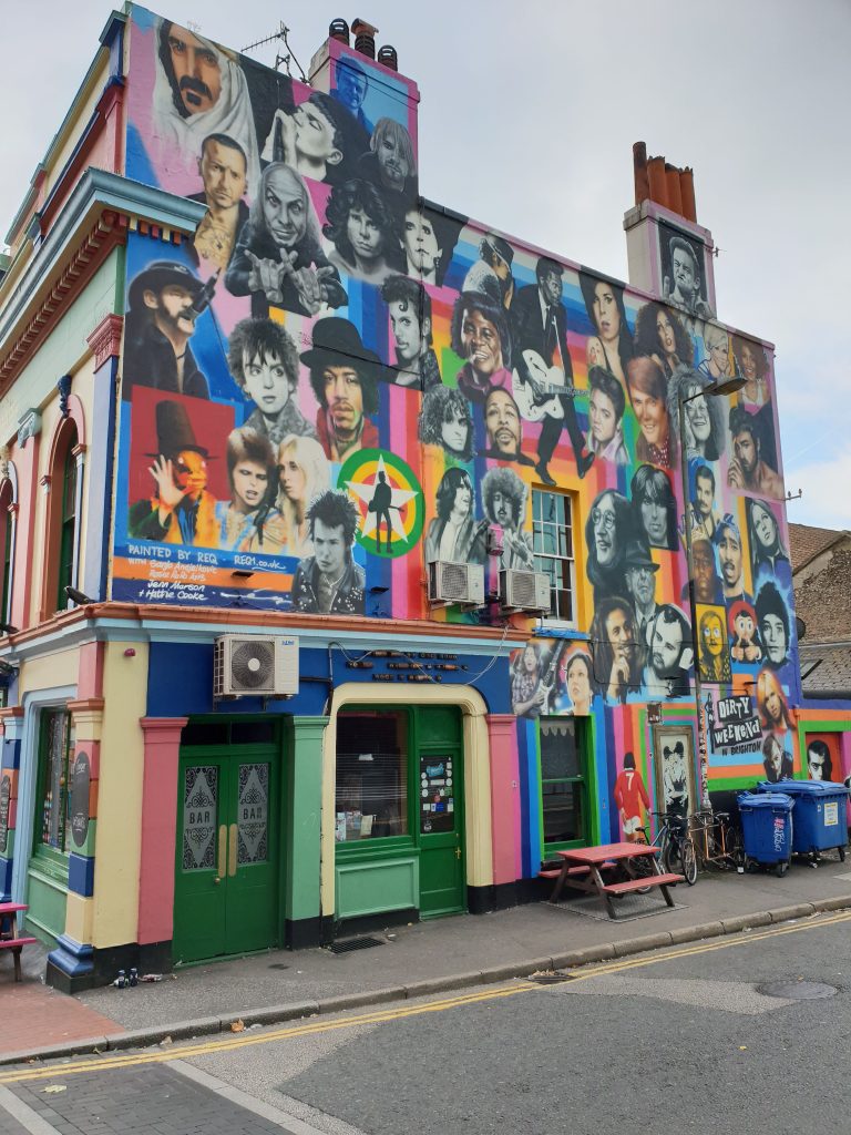 While wandering downtown Brighton for WordCamp Brighton 2018 – I photographed this house which wall has tens of paintings of famous people.