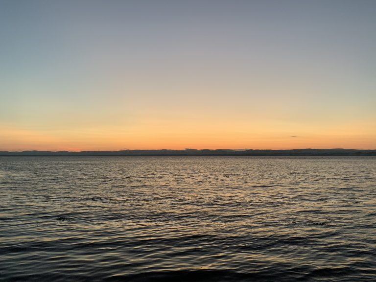 A late evening orange sunset sky over the River Tay viewed from a distance from Newport-on-Tay, Scotland.