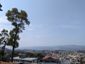Long view looking over the roofs of Shillong city, hills in the distance.
