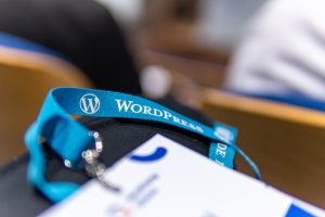 View larger photo: Close-up shot of a lanyard with the Wordpress logo during a conference.