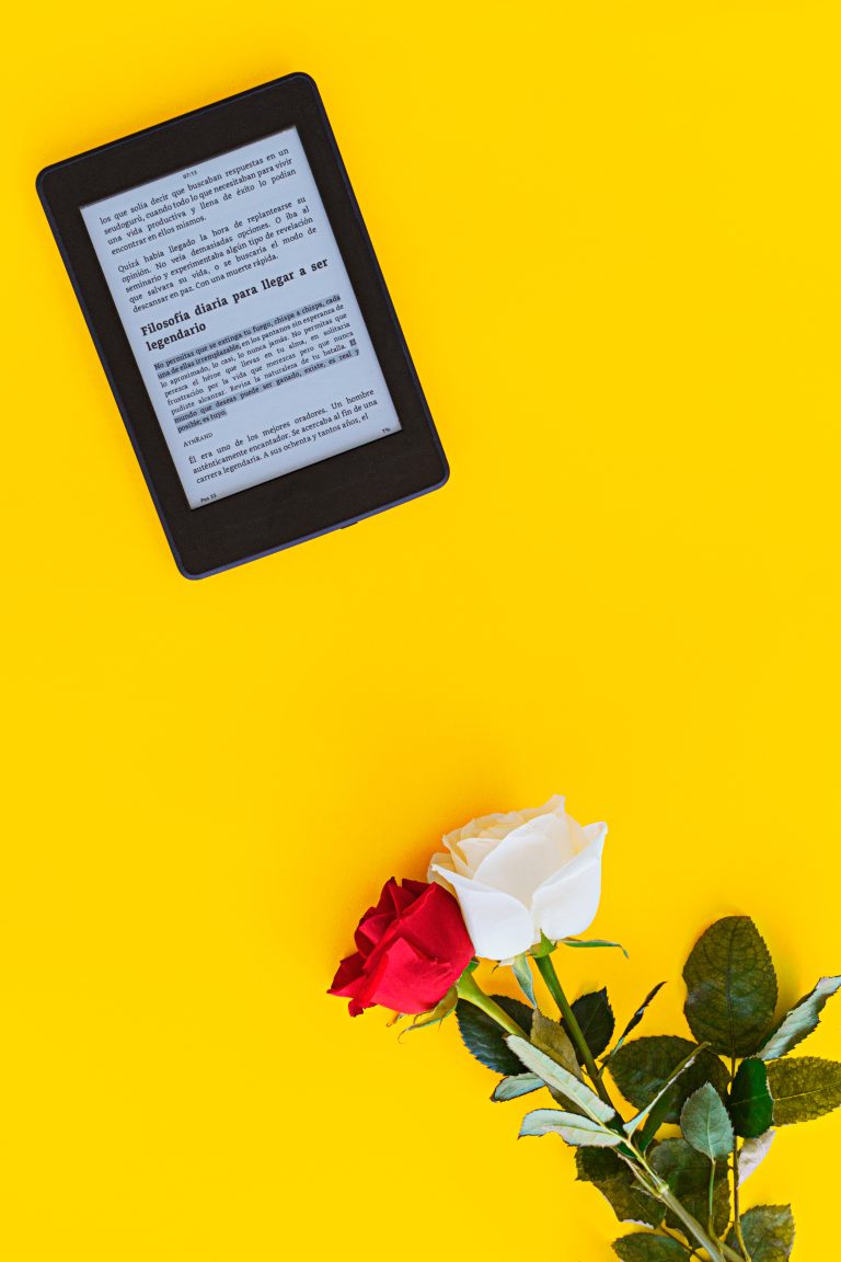 Kindle sobre fondo amarillo con rosas laterales
Kindle on yellow background with side roses