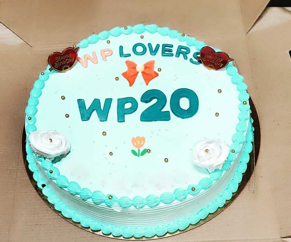 WP20 anniversary cake. Round cake with scallops on the edge with little plastic hearts and frosting roses.