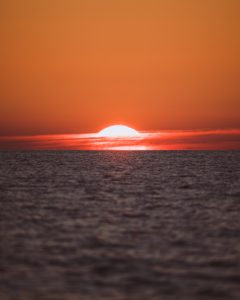 A warm sunset viewed directly on the horizon of the Baltic Sea.

