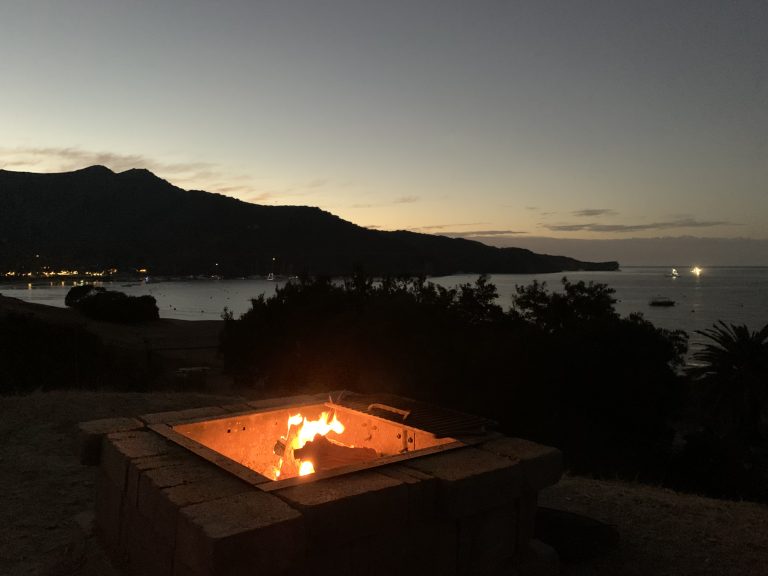 campfire on a bluff overlooking bay