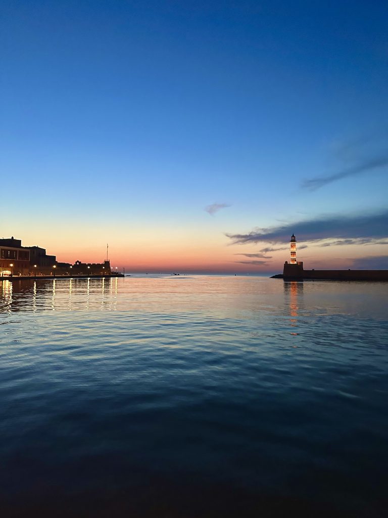 The Lighthouse of Chania, lit up at sunset.