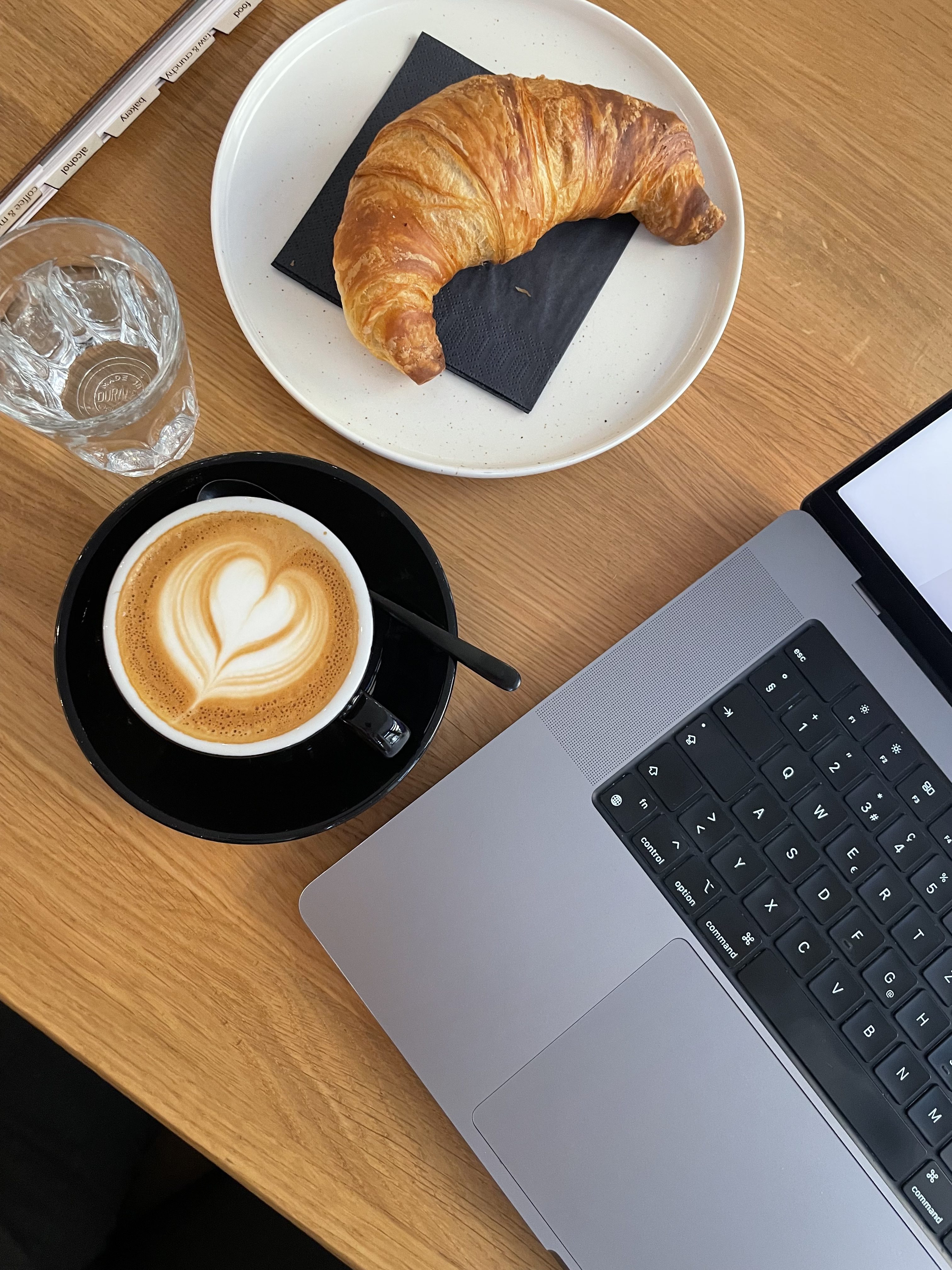 Croissant, coffee and laptop on a table