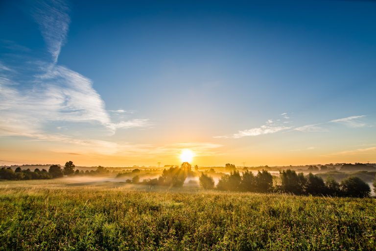 Sunrise viewed over some fields near Schwerin. Sun rays and Fog.