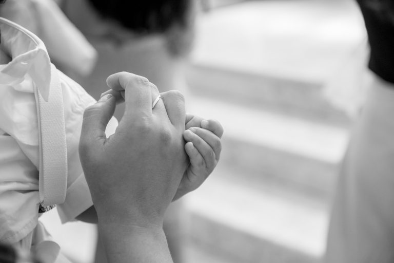 A close-up of a mothers hand holding her baby’s hand