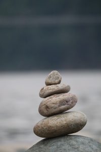 Small rocks stacked on a larger one, largest on the bottom, getting smaller as the stack gets taller.