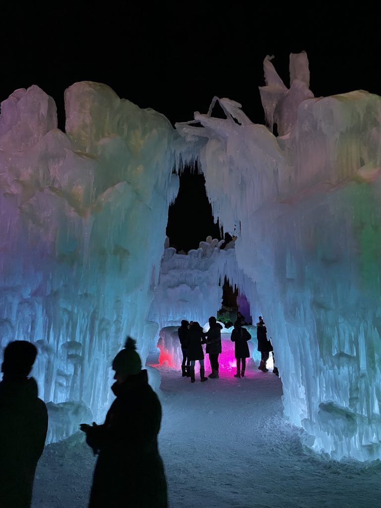 People walking amongst tall ice Castle sculpture