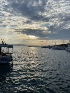 View larger photo: Picture from standing on the bay of marina novi in novi vinodolski looking out on the sea. There is a carpet of clouds with many holes on the sky, the sun is behind the clouds and is soon to set.