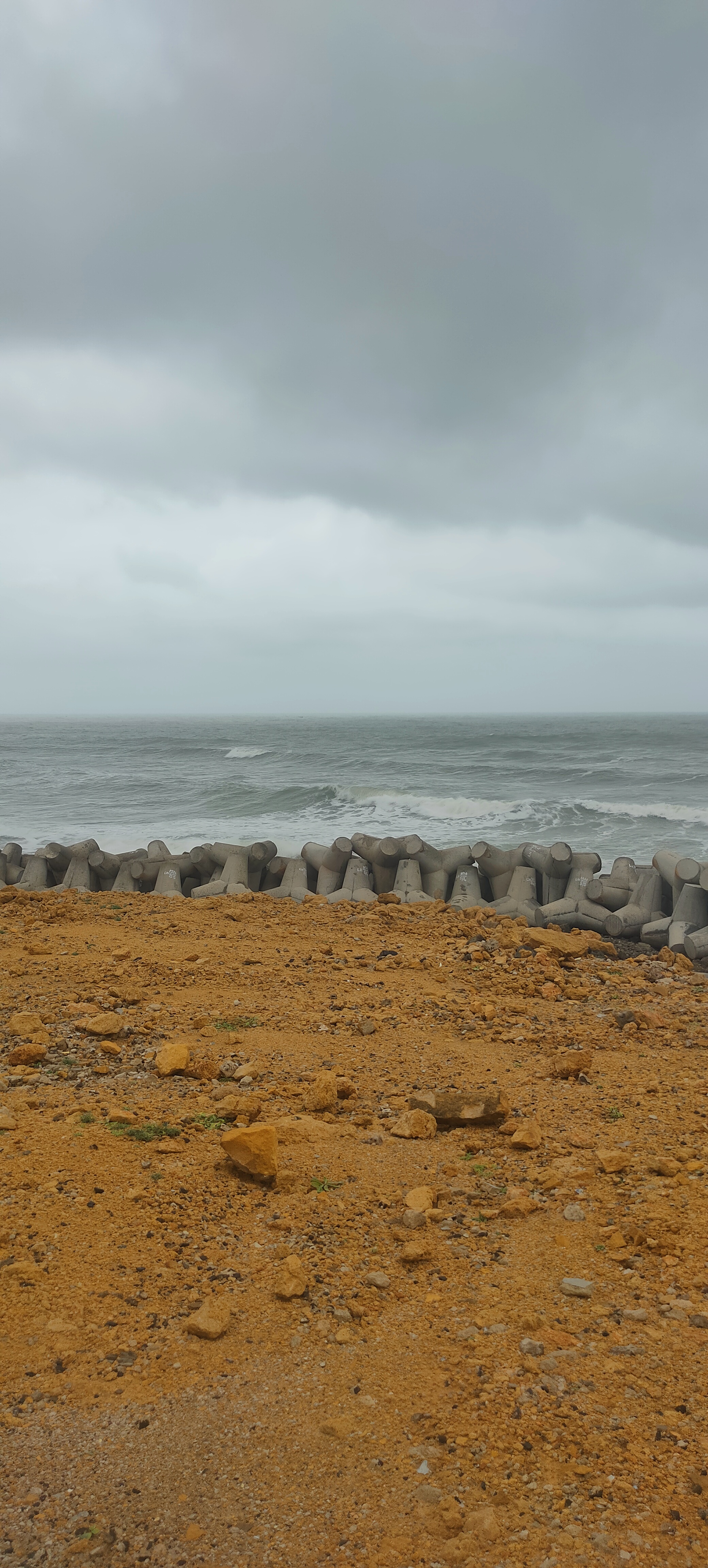 A barricade protects a sandy beach from erosion from the waves of the ocean.