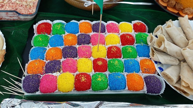 Home made Bangladeshi sweets.  Tray of brightly colored balls in little paper cups.