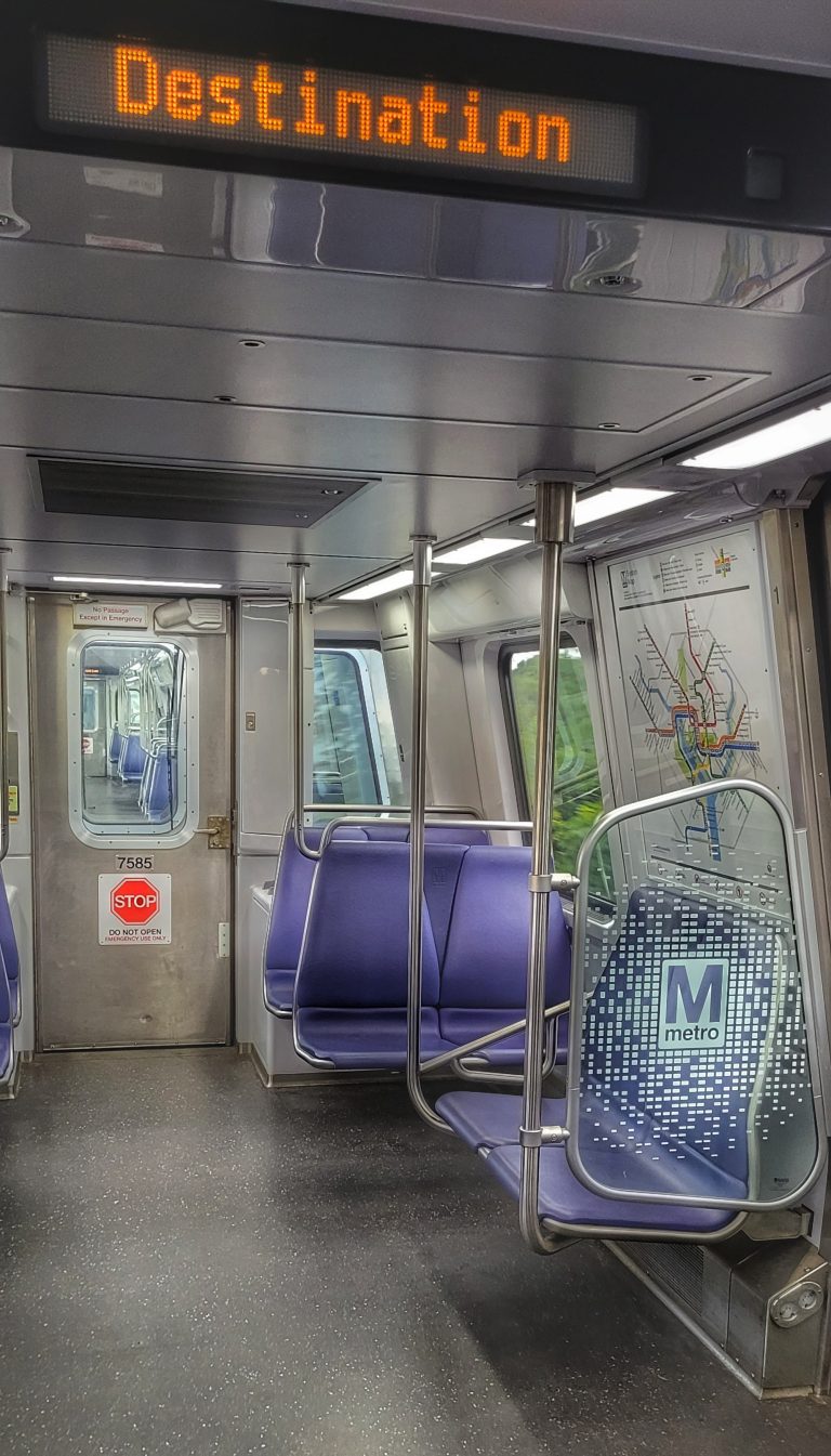 View from inside a Washington DC Metro cab. Silver and white walls and digital read out