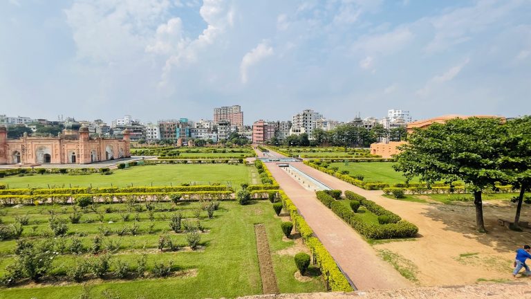 Lalbagh Fort with a clear sky and greenery.