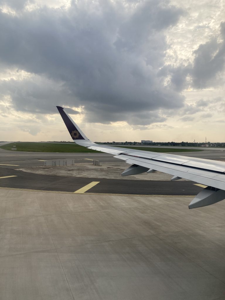 A flight on the runway which ready to take off with the amazing cloud view.