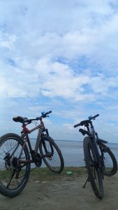 Two bicycles parked at the edge of a body of water.
