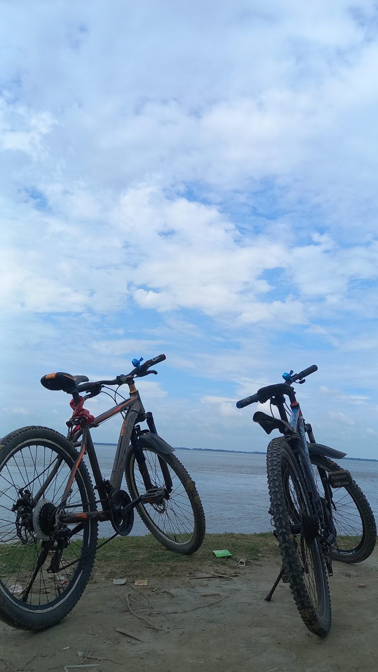 Two bicycles parked at the edge of a body of water.