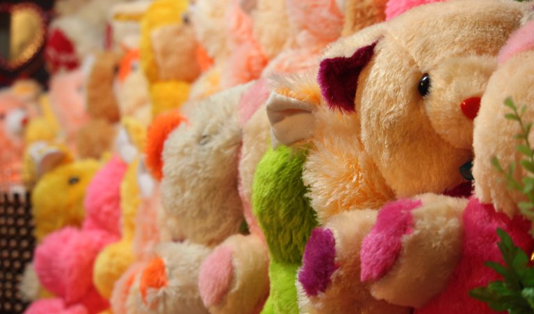 Colourful Teddy Bears aligned in a row at a Shop