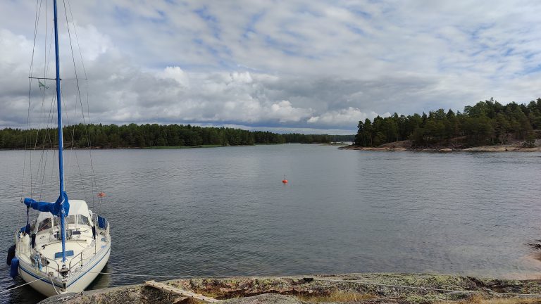 Sea and sailing boat in natural rock harbour.