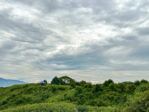 View larger photo: Small Green Hill and Cloudy Sky