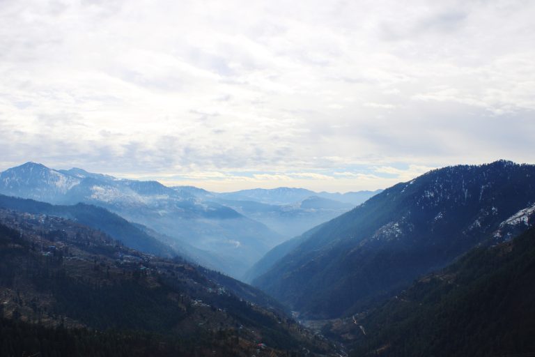 A cloudy sky over mountains and valleys.