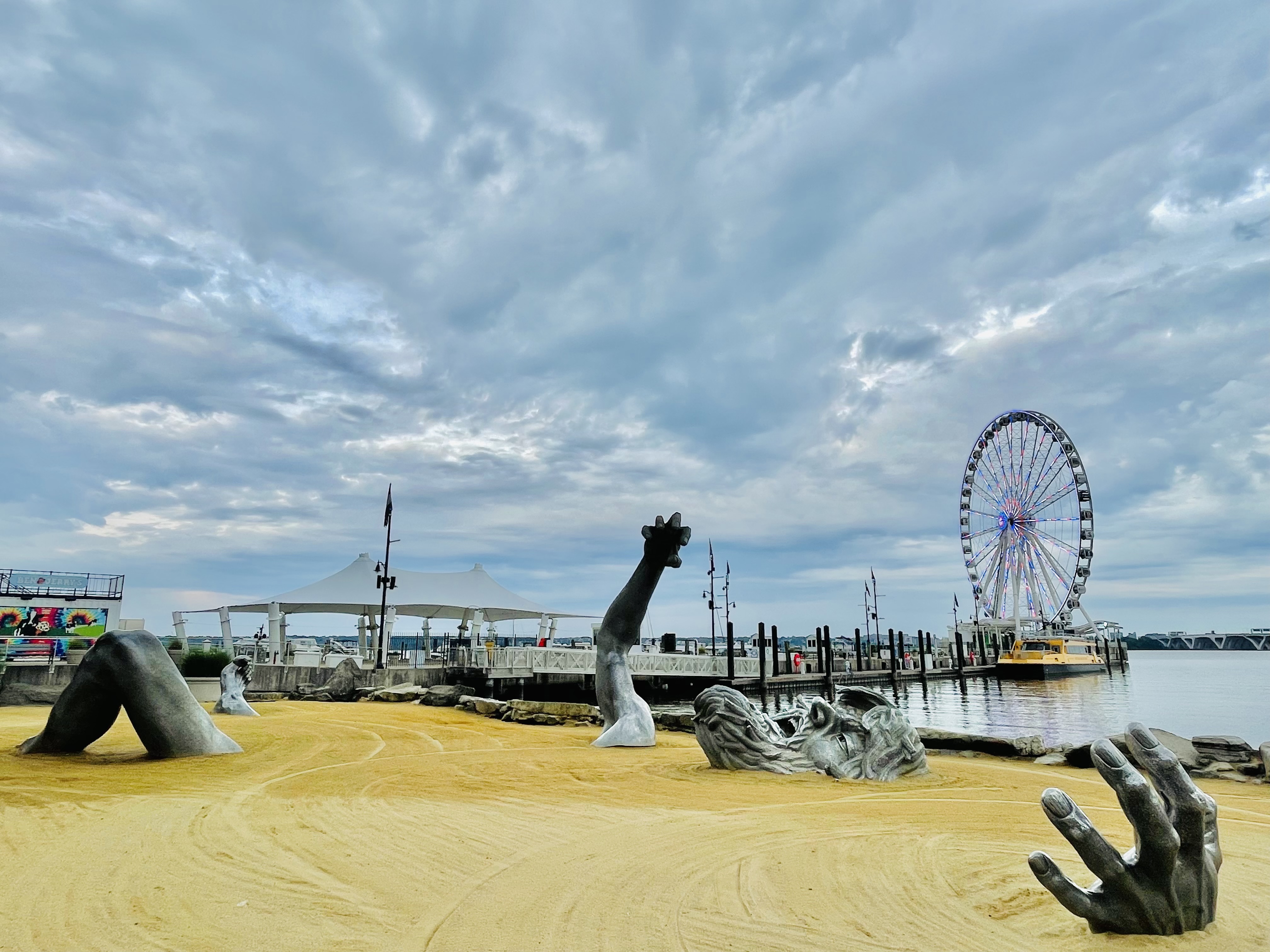 The awakening sculpture(full view)by John Seward Johnson and the Giant Wheel. A famous landmark of National Harbor, Maryland, United States