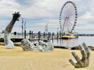 The awakening sculpture by John Seward Johnson and the Giant Wheel. A famous landmark of National Harbor, Maryland, United States