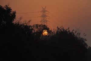 A sunset in Yamuna ghat and electricity line.  
