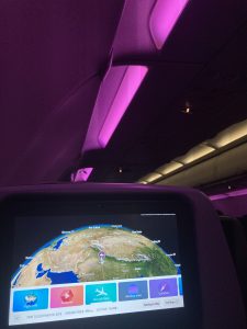 Dark view inside of a flight with the monitor screen in which the destination map is showing.