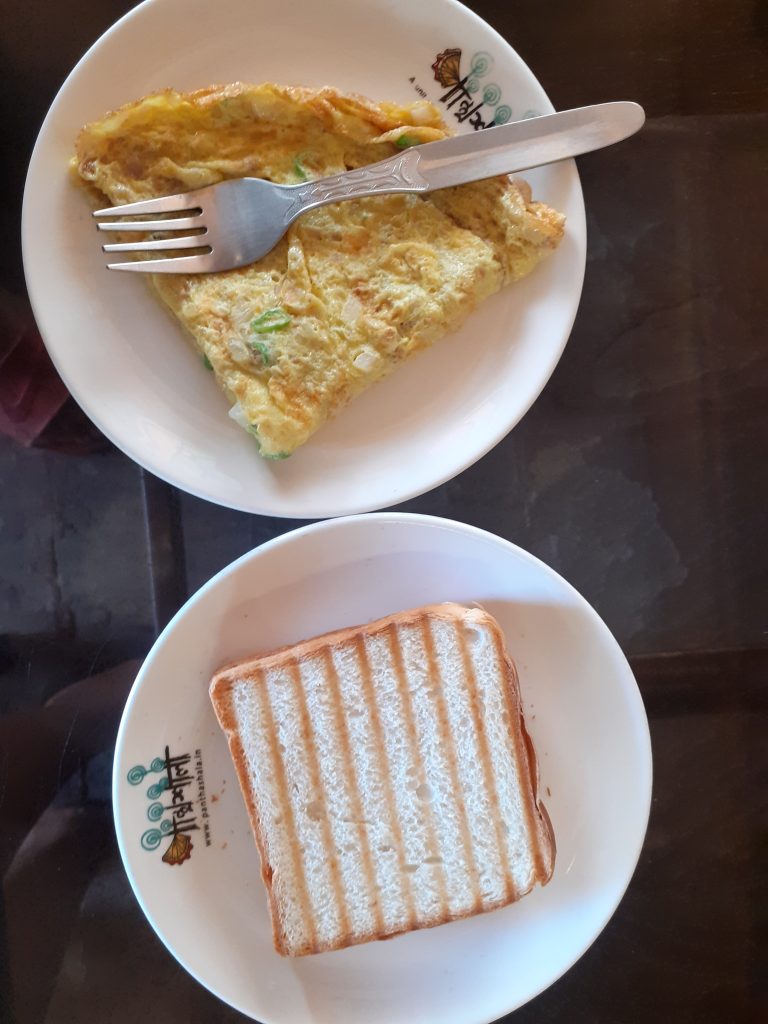 Toast n Omelette in the plate with fork as breakfast.